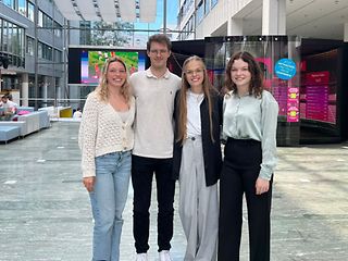 Four young people smile into the camera