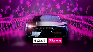 Car with the logos of T-Systems and Aurora Labs.